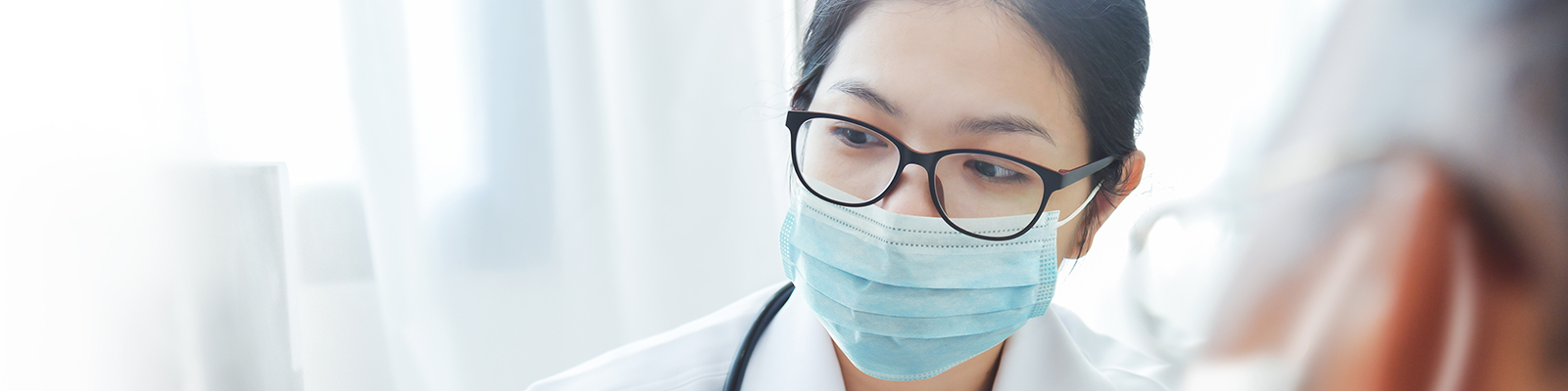 doctor with a mask on facing an older patient 