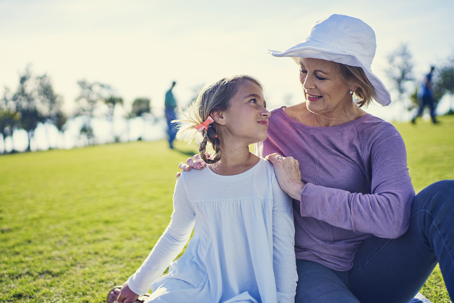 grandmother and granddaughter sitting in a park