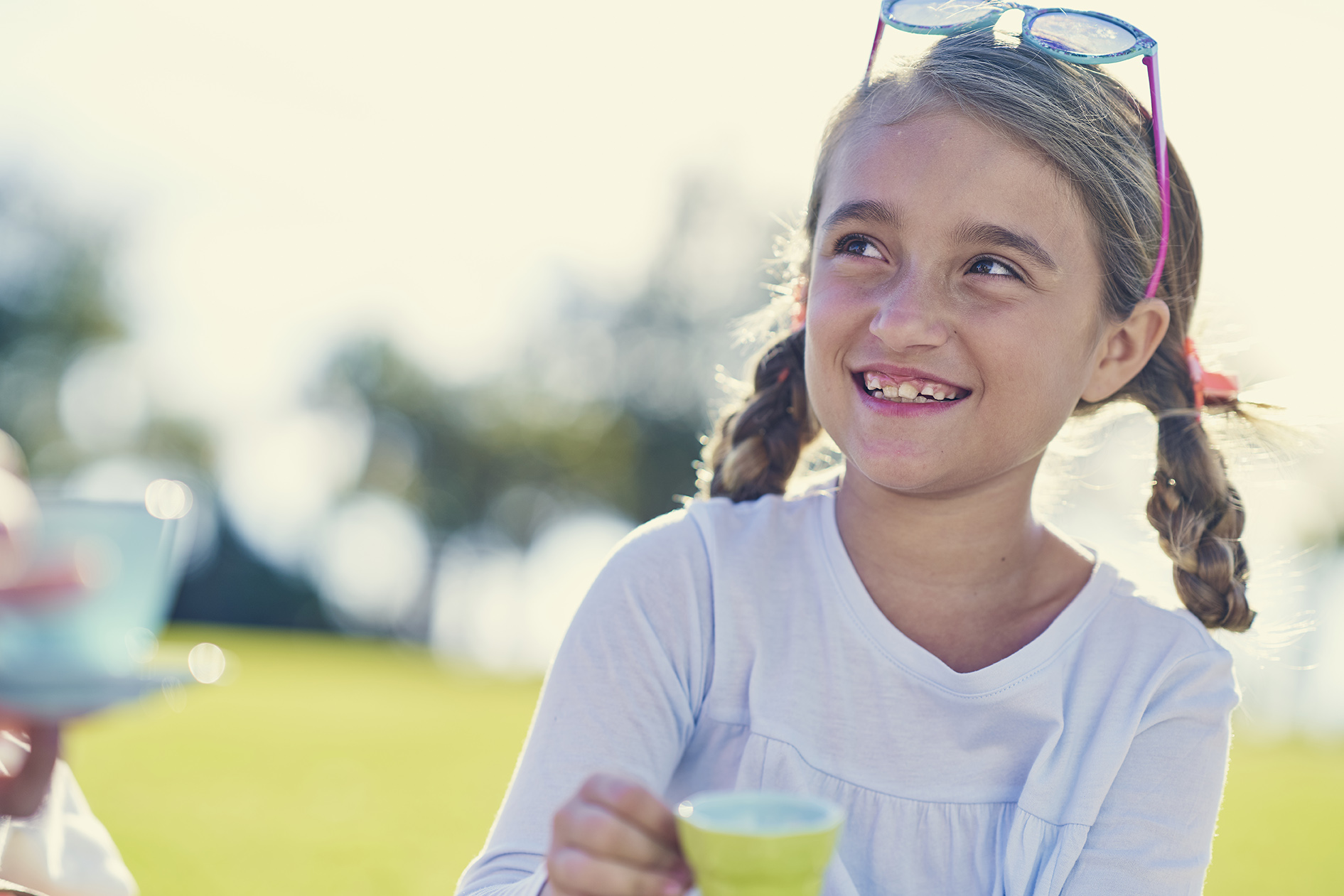 young girl sitting in a park outside