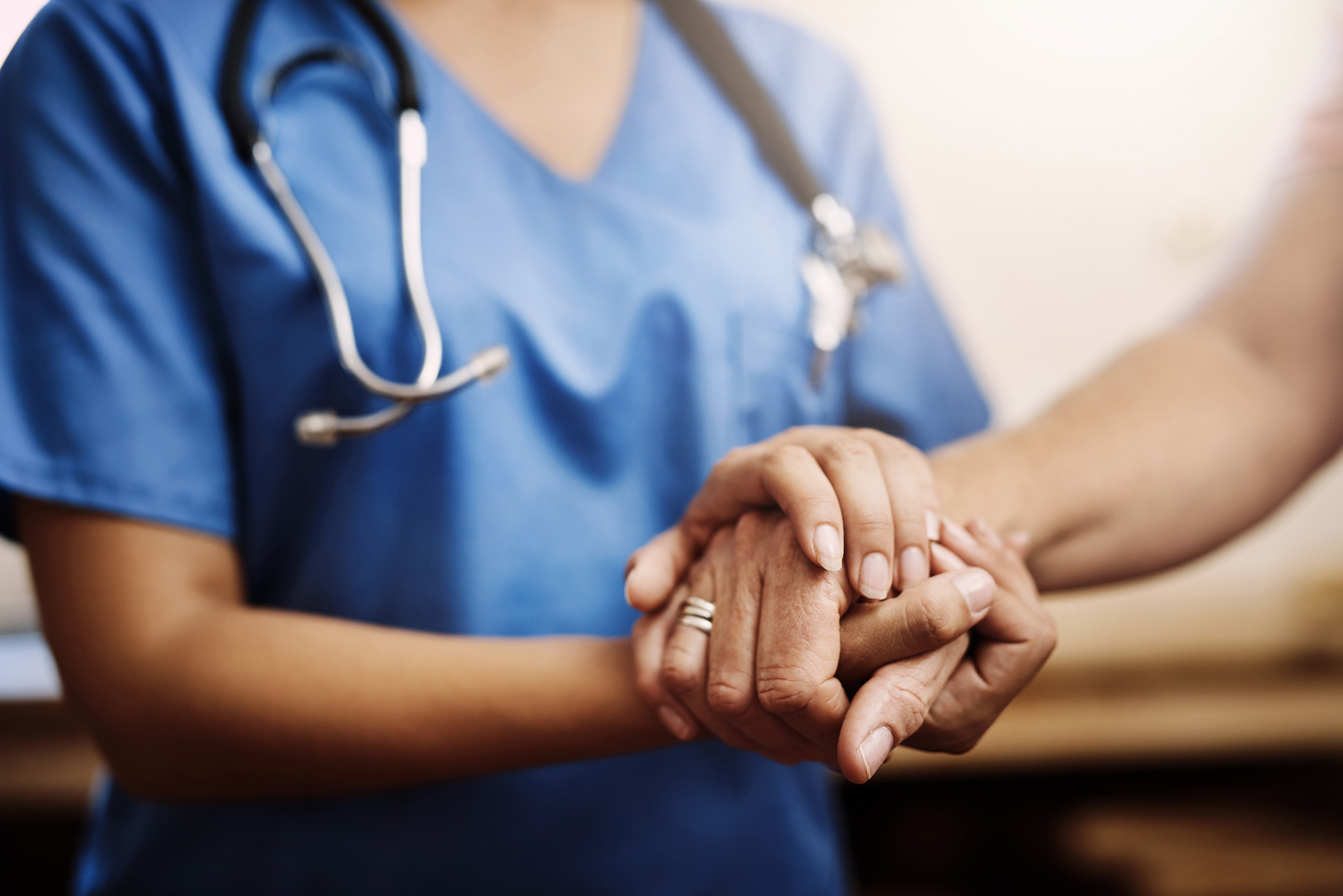 a close up of a doctors hand holding a patients hands