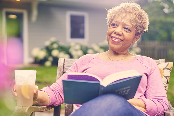 woman reading a book in her yard